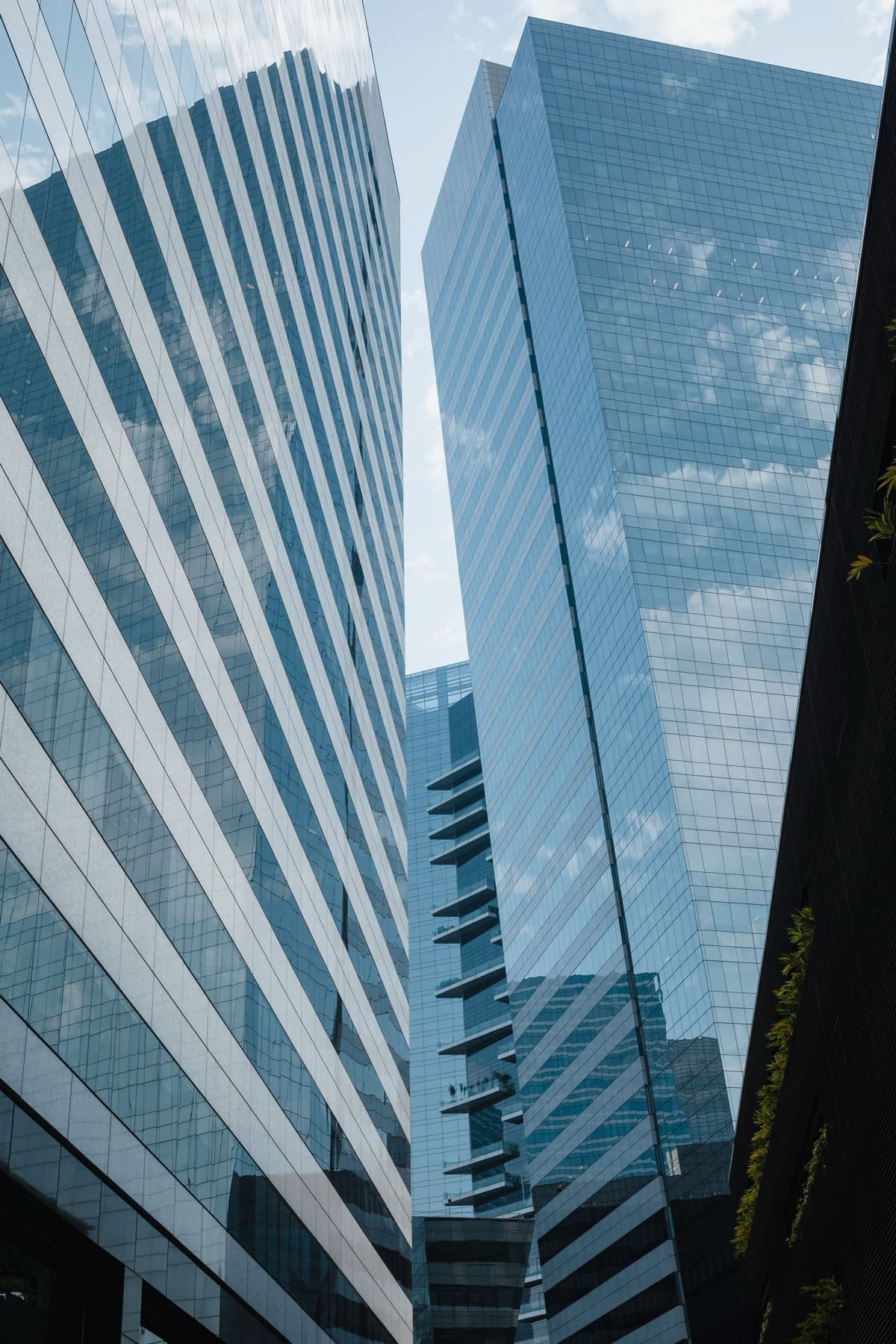 A glass office tower photographed from the plaza below